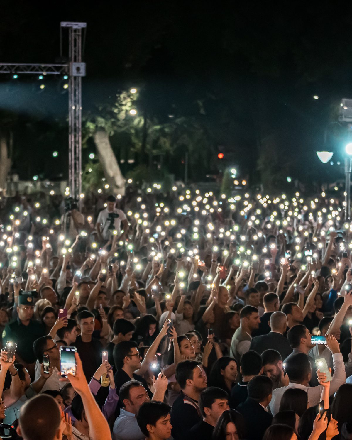 A crowd holding up phone lights at a Stephen Ridley performance